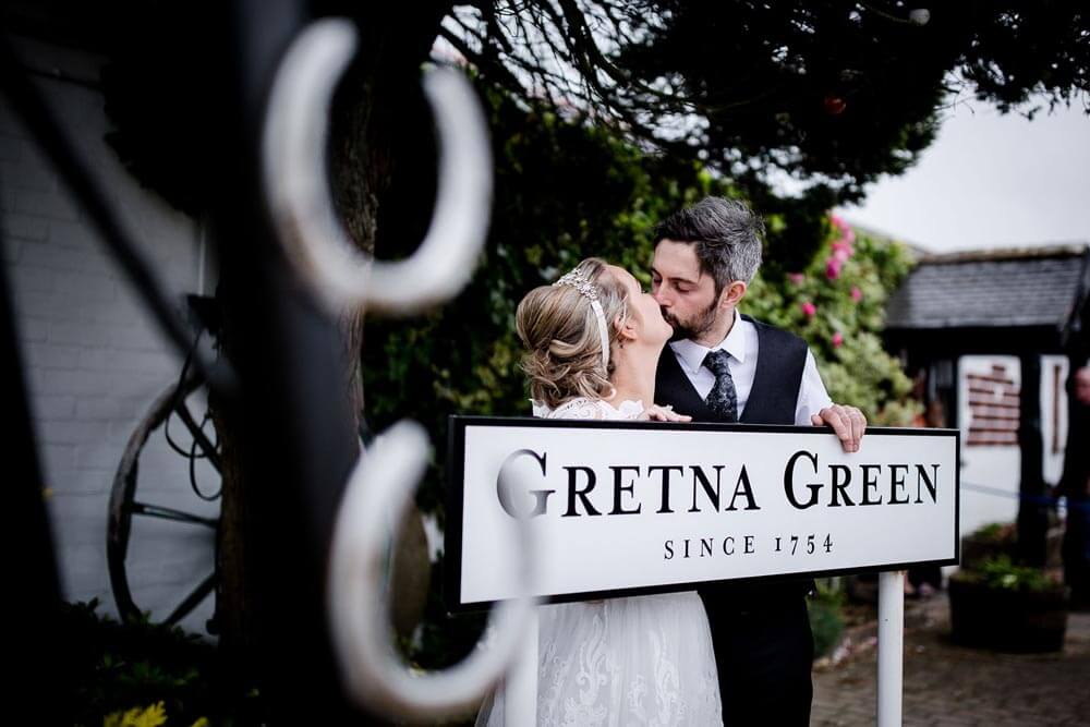 Wedding photo in front of the Gretna Green Since 1754 famous sign