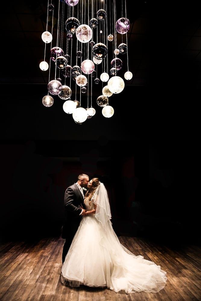Wedding photo under the chandelier in Greens Hotel atrium