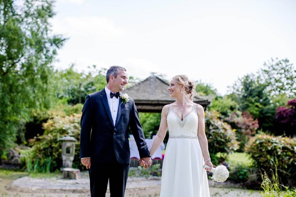 Wedding photo in front of the wedding pergola in the Water Gardens at Greens hotel, Gretna